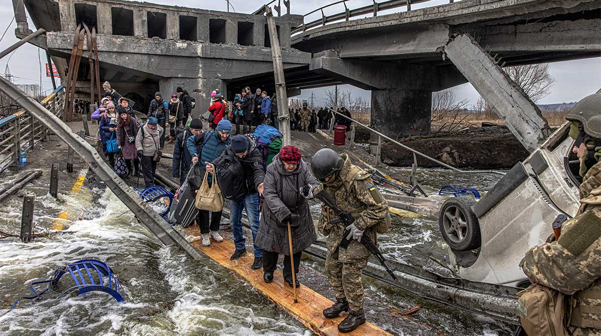 Le 7 mars 2022, ces personnes traversent un pont détruit, alors qu’elles fuient la ville d’Irpin, à 10 km de Kiev, la capitale de l’Ukraine. © EPA-EFE/ROMAN PILIPEY/MAXPPP